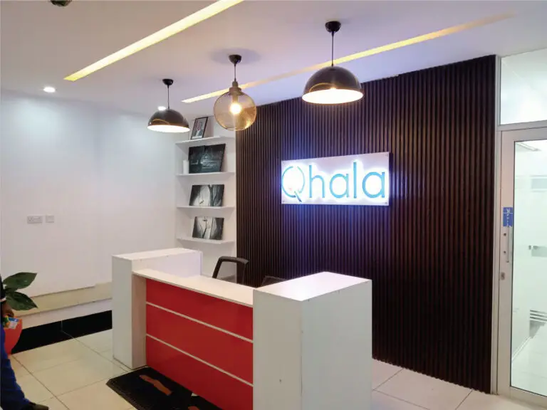 Modern reception partition and front desk installation by office partition contractors in Nairobi Kenya with wood slat wall and illuminated logo.