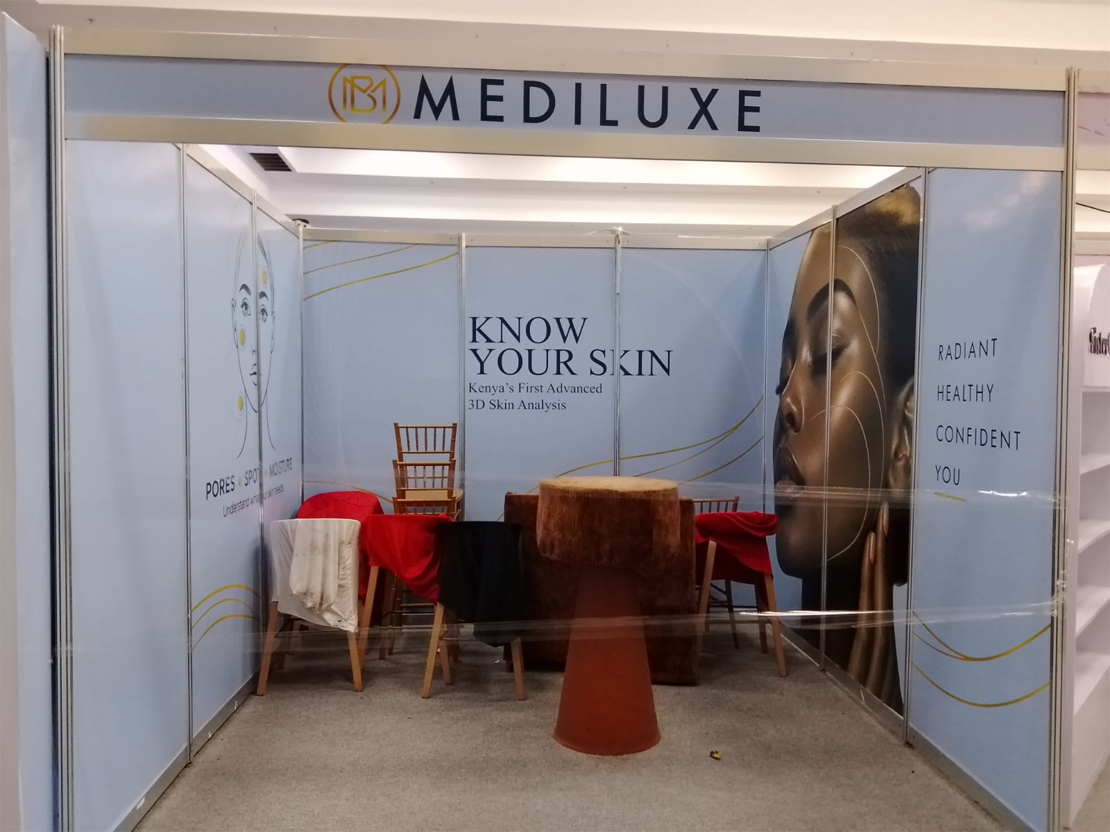 Mediluxe shell-scheme booth with skincare graphics during setup