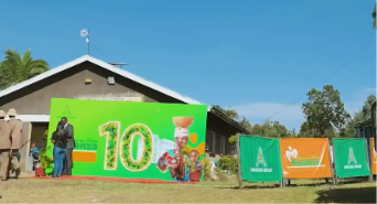 Green Mama na Mtoto outdoor event backdrop with printed campaign artwork and branded barrier banners.